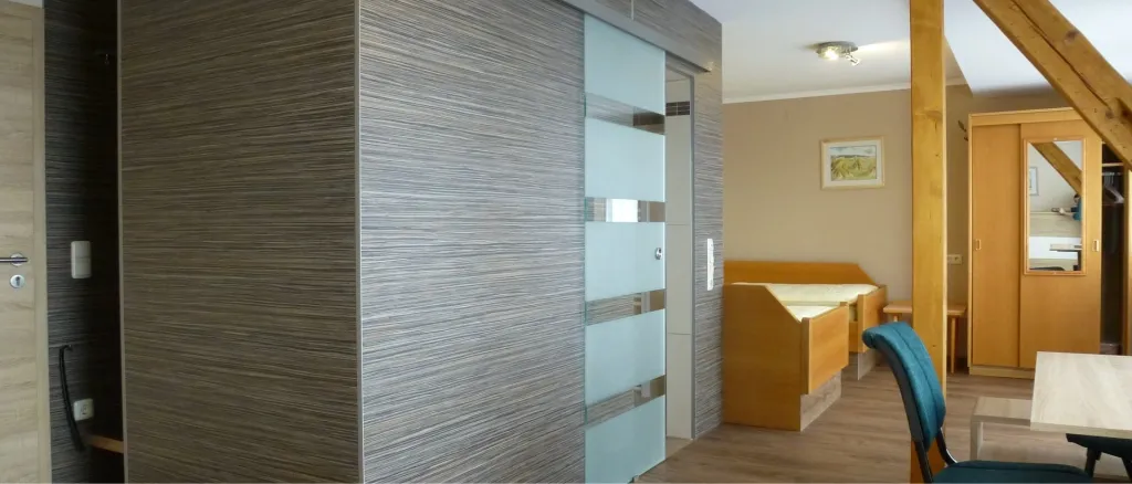 Schiebetür mit Glaseinsätzen als Zugang zu einem Hotelzimmer