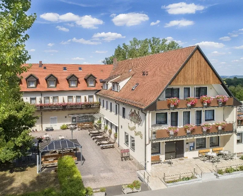 Luftaufnahme des Hotel-Gasthofs zum Bartl mit Biergarten und Parkplatz im Sommer