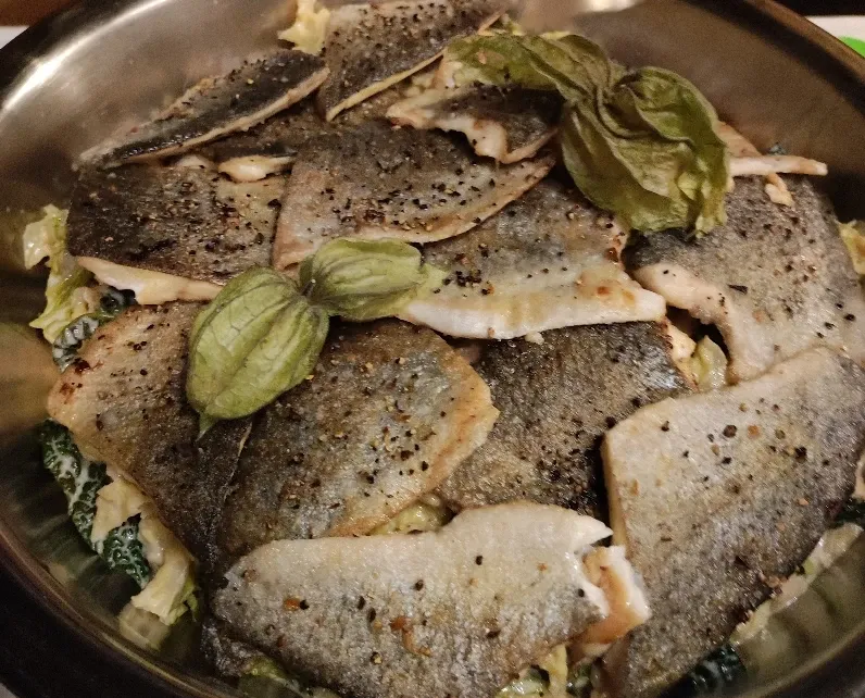 Pfanne mit gebratenen Fischfilets, Kräutern und Lorbeerblättern