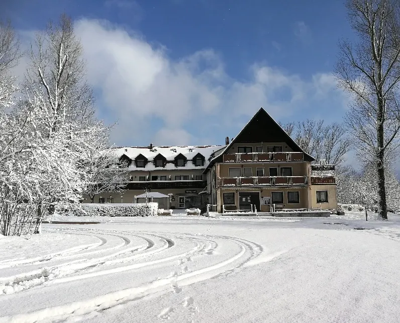 Verschneiter Hotel-Gasthof zum Bartl im Winter mit weiß bedeckten Bäumen