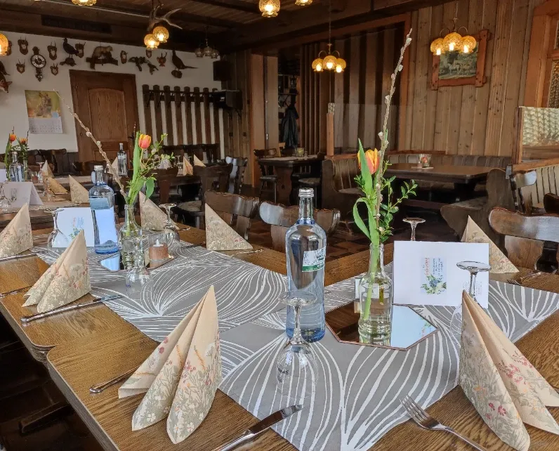 Jägerzimmer mit für eine Veranstaltung eingedeckter Tafel mit Tulpen und Wasserflaschen